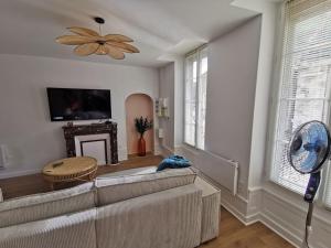 a living room with a couch and a ceiling fan at Les clos de Givry - Clos Léonie - Appartement 68m2 spacieux, lumineux et avec sauna in Givry