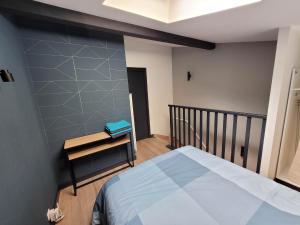 ein Schlafzimmer mit einem Bett und einem kleinen Tisch in der Unterkunft Duplex Mon Désert - Parc Sainte Marie - Nancy Thermal in Nancy