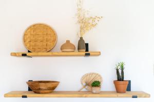 une étagère avec des vases et des plantes sur un mur dans l'établissement Surmar - Apartamento con piscina en Cap d'Artrutx, à Cala'n Bosch 8 autres photos