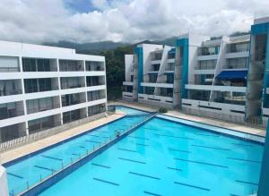 una grande piscina di fronte a due edifici di Aloja-T en Apartamento amoblado en Condominio de San Jeronimo a San Jerónimo