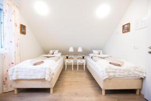 two twin beds in a room with white walls at Guesthouse Grund in Grindavík