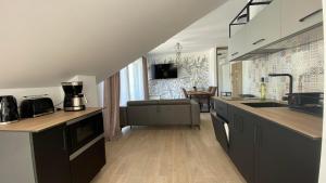 a kitchen with a sink and a living room at NATURAvistaMARE I in Dziwnów