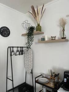 イストルにあるStudio chez jossの壁に花瓶と時計が飾られた部屋