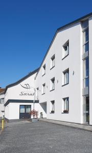 a white building with a sign on the side of it at Hotel Sarah in Heinsberg