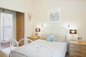 a bedroom with a white bed and two night stands at 10 Trehawks in Wadebridge