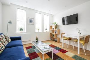 a living room with a blue couch and a table at Perfect City Centre Location - Historic Albion Mews in Chester