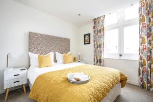 1 dormitorio con 1 cama con colcha amarilla en Perfect City Centre Location - Historic Albion Mews, en Chester