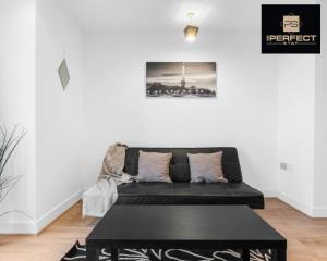 a living room with a black couch and a table at Mercury Suite CITY CENTRE Netflix Dedicated Workspace By Your Perfect Stay Short Lets Birmingham in Birmingham
