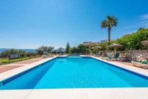 una piscina en una villa con palmeras en Cantueso Holiday Park, en Periana