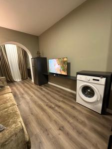 a living room with a washing machine and a tv at Bejart Apartment 4 in Tirana