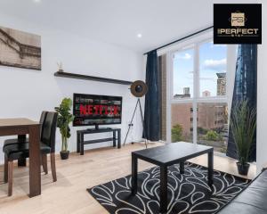 a living room with a couch and a table and a tv at Mercury Suite CITY CENTRE Netflix Dedicated Workspace By Your Perfect Stay Short Lets Birmingham in Birmingham