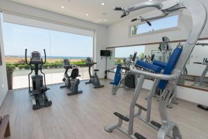 a gym with several tread machines and a large window at Loutsiana Deluxe Apts in Ayia Napa