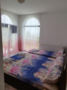 a bedroom with a large bed with flowers on it at Family Hotel Kentavar 2 in Byala