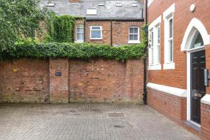 una pared de ladrillo junto a un edificio con hiedra en Perfect City Centre Location - Historic Albion Mews, en Chester