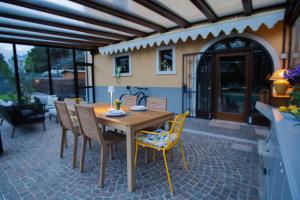 a wooden table and chairs on a patio at Villetta al lago in Nago-Torbole +1 photo