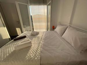 een wit bed met een afstandsbediening erop bij Villa Μyrtali in Meganisi