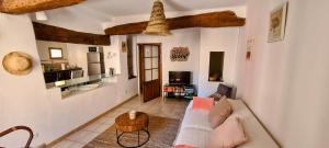 ein Wohnzimmer mit Sofa und Tisch in der Unterkunft La Terrasse d'Oléa, au coeur du village in Buis-les-Baronnies