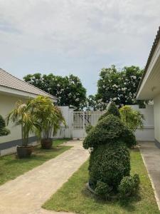 eine Buschstatue im Hof eines Hauses in der Unterkunft Loma-asunto Hua Hin Soi 94 Baan Finland apartment 28 in Hua Hin