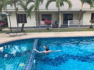 Eine Frau, die im Schwimmbad schwimmt. in der Unterkunft Loma-asunto Hua Hin Soi 94 Baan Finland apartment 28 in Hua Hin + 3 Fotos