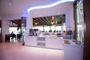 a kitchen with white counters and a large window at Loutsiana Deluxe Apts in Ayia Napa