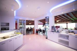 a kitchen with white counters and people in the background at Loutsiana Deluxe Apts in Ayia Napa