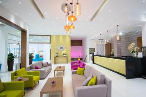 a living room with colorful chairs and couches at Loutsiana Deluxe Apts in Ayia Napa