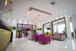 a lobby with purple and yellow chairs and tables at Loutsiana Deluxe Apts in Ayia Napa