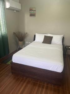 - une chambre dotée d'un lit avec des draps blancs dans l'établissement Apartment Rental, à Paix Bouche