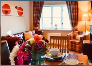 una sala de estar con una mesa con un jarrón de flores en 3 Bedroom harbourside apartment, Queensferry, 10 miles from Edinburgh en Queensferry