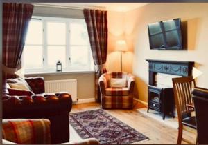 sala de estar con sofá, silla y chimenea en 3 Bedroom harbourside apartment, Queensferry, 10 miles from Edinburgh, en Queensferry