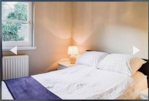 1 dormitorio con cama blanca y ventana en 3 Bedroom harbourside apartment, Queensferry, 10 miles from Edinburgh, en Queensferry