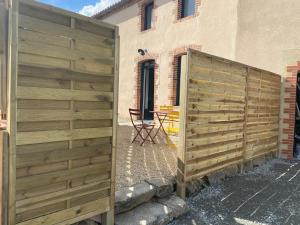 una recinzione di legno di fronte a un edificio di Gîte O Petit Bouchon à 10 min du Puy du Fou a Sevremont