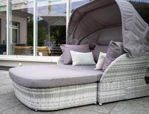 a futon bed with pillows on a patio at Hotel Sternen Unterwasser in Unterwasser