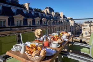 パリにあるMajestic Hotel Spa - Champs Elyséesのテーブル(パン、ペストリーのバスケット付)