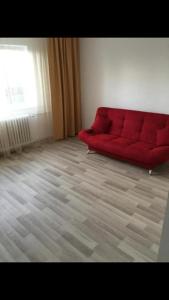 um sofá vermelho sentado numa sala de estar em Apartament Tiffany em Cluj-Napoca