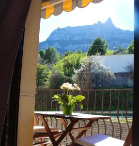 einen Tisch mit einer Blumenvase auf dem Balkon in der Unterkunft Barcelo al riu in Monistrol de Montserrat