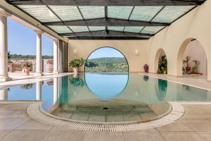 einen Innenpool mit einem Bogenfenster und einem Pool in der Unterkunft Suite Il Focolare, Villa Nemora in Castello di Montalto