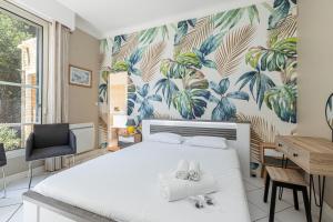 Un dormitorio con una cama blanca con dos zapatos. en VILLA CRUG HYWEL - VILLEFRANCHE-SUR-MER, en Villefranche-sur-Mer