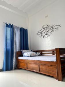 a bedroom with a wooden bed with blue curtains at FN Lodge - town proper in Palompon