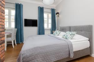 a bedroom with a large bed with blue curtains at City Center Aparthotel Chmielna by Noclegi Renters in Warsaw