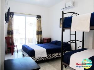 Hostal Playa Imperial Manta في مانتا: غرفة نوم بسريرين بطابقين ونافذة