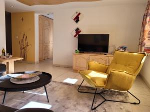 サース・アルマゲルにあるHaus Faderhornのリビングルーム(黄色い椅子2脚、テレビ付)