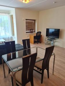 uma sala de estar com uma mesa e cadeiras e uma televisão em Cozy one bedroom apartment in city center em Talin