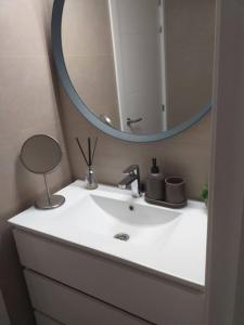 a bathroom with a white sink and a mirror at Precioso piso en Almería centro con parking gratis in Almería