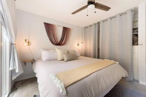 1 dormitorio con 1 cama blanca y ventilador de techo en YellowDoorBeachHouse close to Moonlight Beach and LEGO Land, en Encinitas
