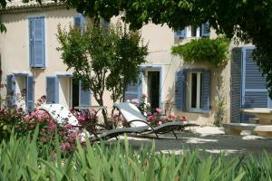 2 sillas blancas en un jardín frente a un edificio en Mirabelle en Provence, en Eygalières