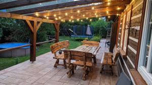 a patio with a table and chairs and lights at Wellness chata - Krkonoše in Rudník