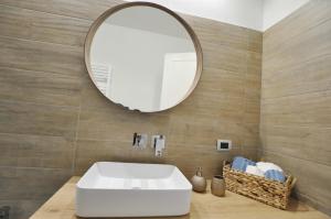 a bathroom with a white sink and a mirror at Dalila's Apartment in Sirmione +32 photos