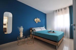 a blue bedroom with a bed and a mirror at Dalila's Apartment in Sirmione