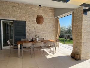 a dining room with a wooden table and chairs at Villa Tina Maria with seaview near Porec in Markovac